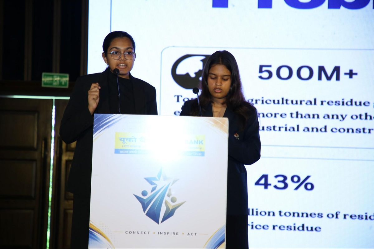Two Huskell Co. presenters at the podium in front of a slide on agricultural residue